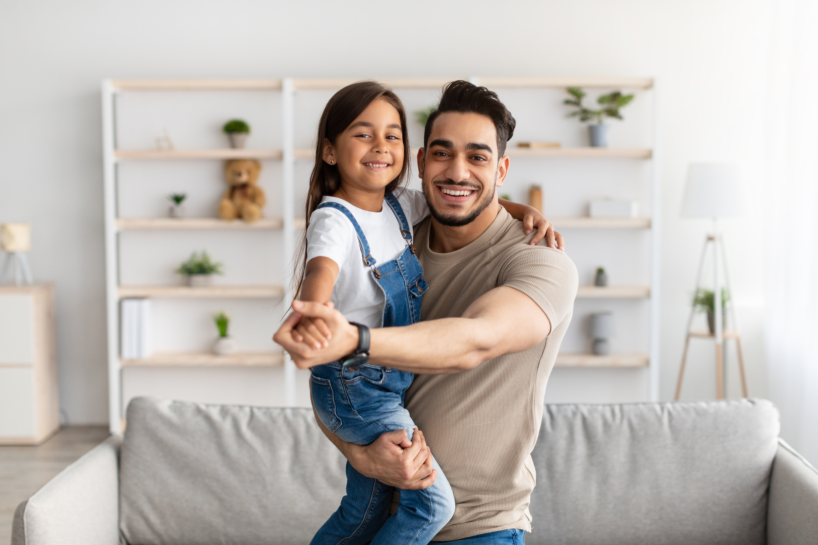 Dad and daughter dancing in living room together